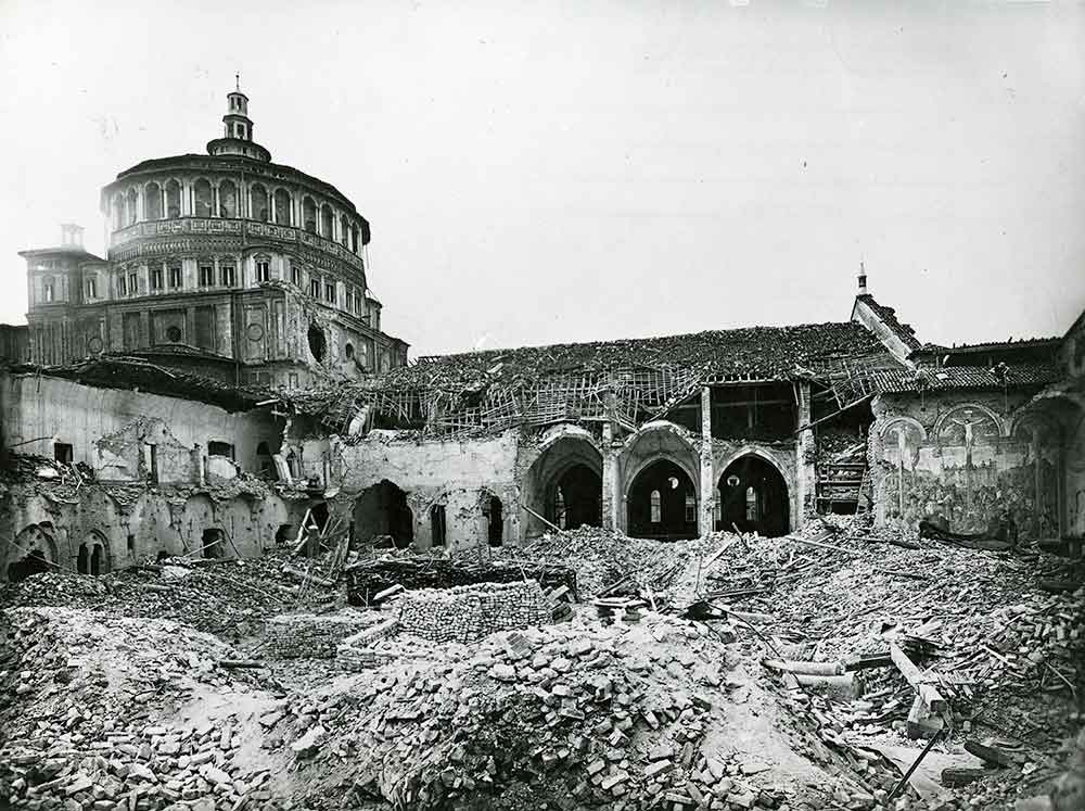 The refectory of Santa Maria delle Grazie, Milan, after the Allied bombing of 15 August 1943. The north wall, bearing The Last Supper, remained standing amid the ruins. Public domain.