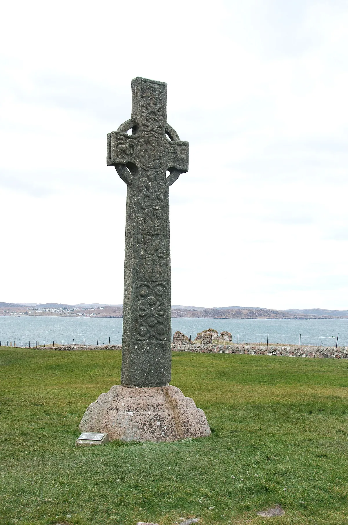 Saint Martin's Cross standing outside Iona Abbey, a tall carved stone high cross with a ringed head against a grey sky