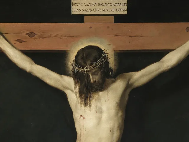 Christ on the cross, his head crowned with thorns and bowed beneath the inscription INRI, his arms stretched along the wooden beam against a dark background